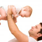 отец подкидывает маленького ребенка